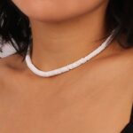 A person wearing a beautifully crafted Puka Shell Necklace, embodying the essence of the sea.